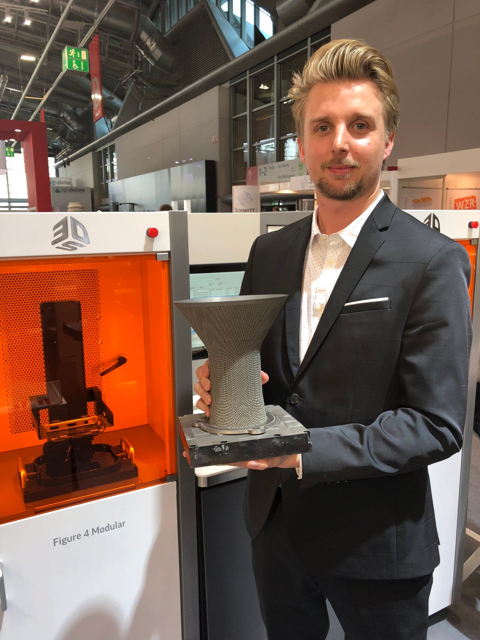 David, Gründer von Meltlab, mit einem 3D-gedruckten Bauteil auf einer Fachmesse